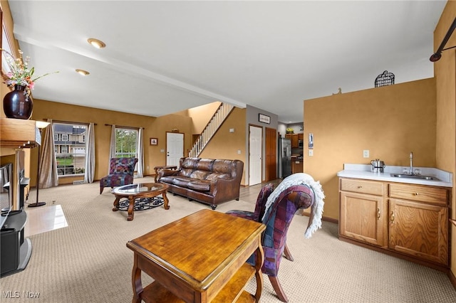 living area featuring light colored carpet and stairway