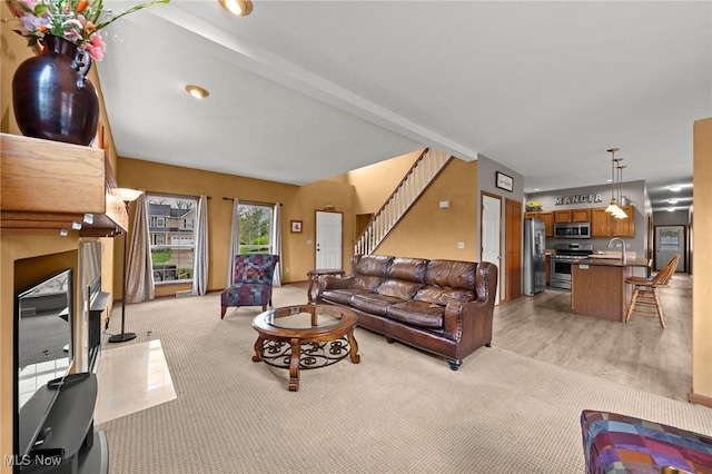 living room featuring stairs, light carpet, and light wood-type flooring