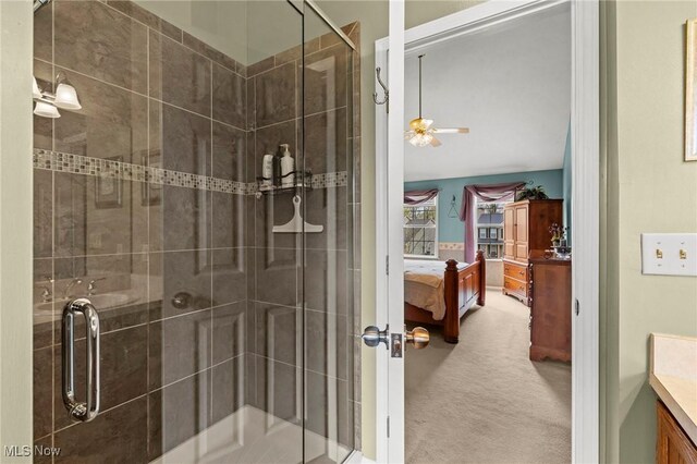 ensuite bathroom featuring vanity, ceiling fan, a stall shower, and ensuite bath