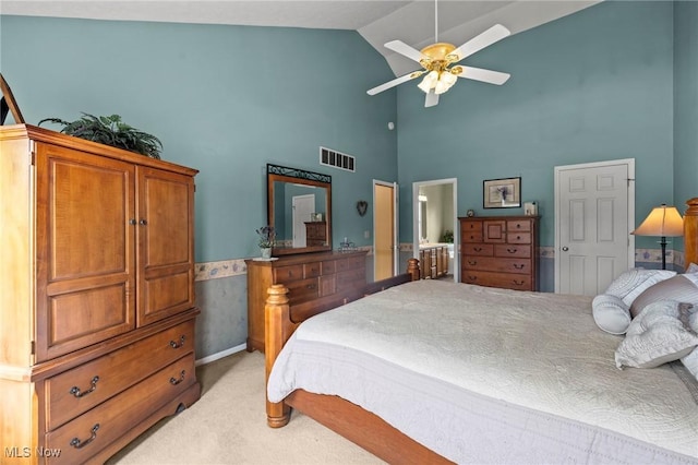 bedroom featuring ceiling fan, visible vents, high vaulted ceiling, connected bathroom, and light carpet