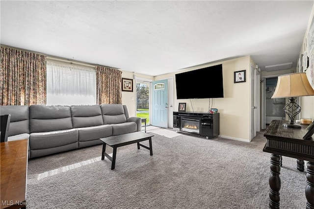 living area with baseboards, carpet flooring, and a glass covered fireplace