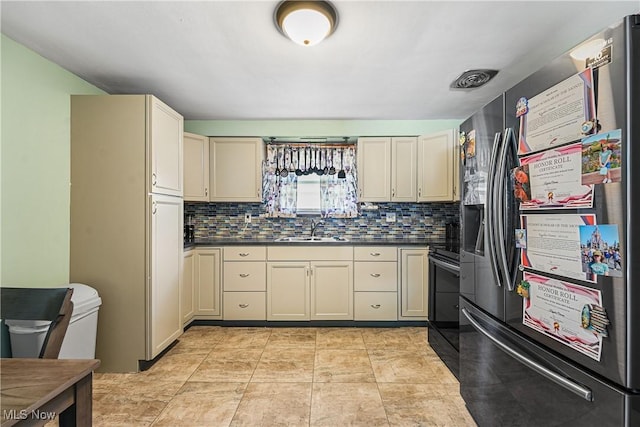 kitchen with stainless steel refrigerator with ice dispenser, dark countertops, electric range, and a sink