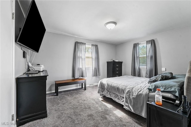 carpeted bedroom with multiple windows, baseboards, and visible vents