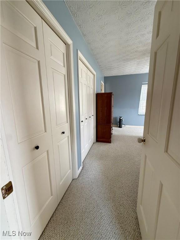 7455 Brushmore Ave NW, North Canton, OH 44720 - corridor featuring a textured ceiling and carpet