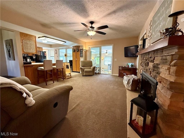 7455 Brushmore Ave NW, North Canton, OH 44720 - living area with carpet floors, a ceiling fan, a textured ceiling, and a stone fireplace
