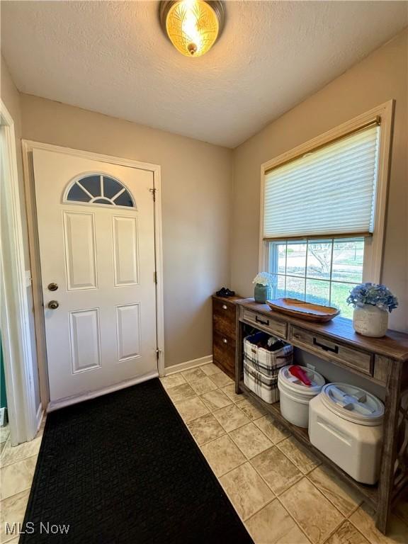 7455 Brushmore Ave NW, North Canton, OH 44720 - foyer featuring a textured ceiling and baseboards