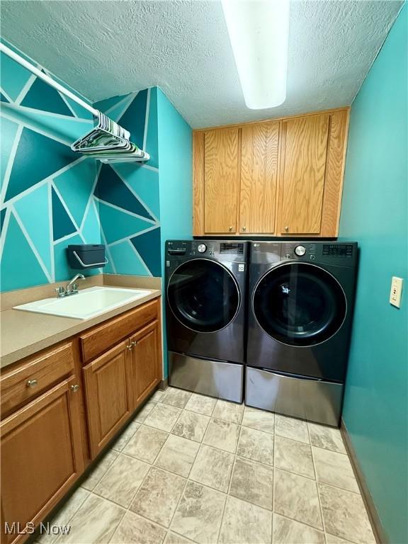 7455 Brushmore Ave NW, North Canton, OH 44720 - washroom with cabinet space, washing machine and dryer, and a textured ceiling