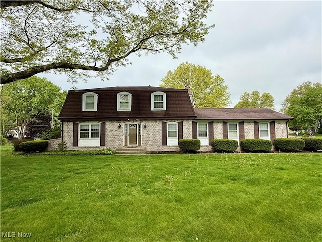 7455 Brushmore Ave NW, North Canton, OH 44720 - view of front facade with mansard roof, a front yard, and brick siding