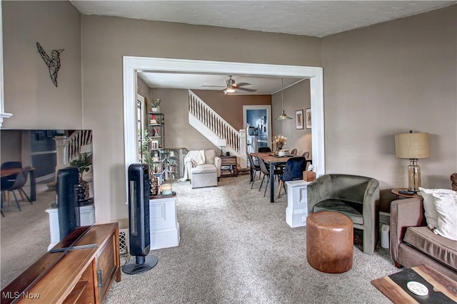living room featuring ceiling fan, stairs, and carpet