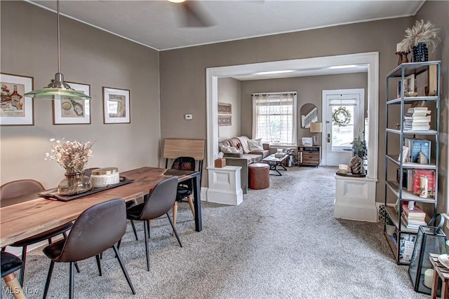 carpeted dining area featuring crown molding