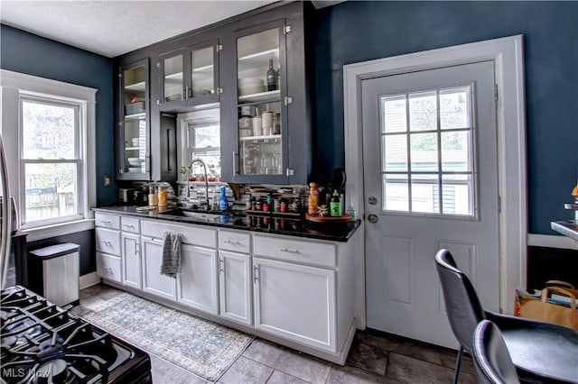 bar with gas stove, a sink, and baseboards