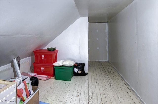 additional living space with lofted ceiling and hardwood / wood-style flooring