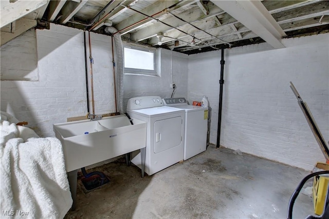 washroom with a sink, independent washer and dryer, and laundry area