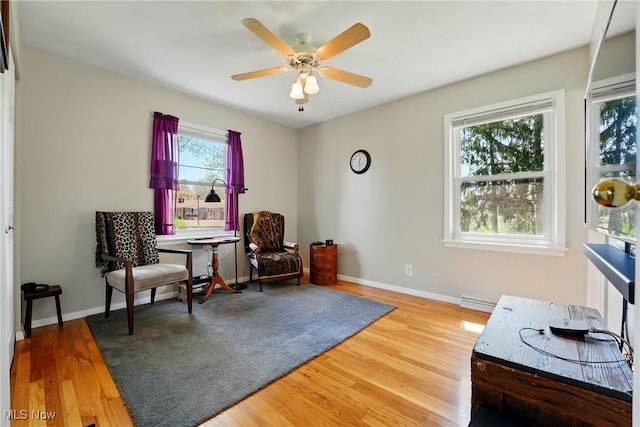 sitting room with wood finished floors, a ceiling fan, visible vents, and baseboards