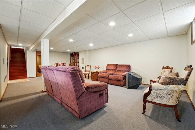 living room featuring stairs, carpet floors, and a paneled ceiling