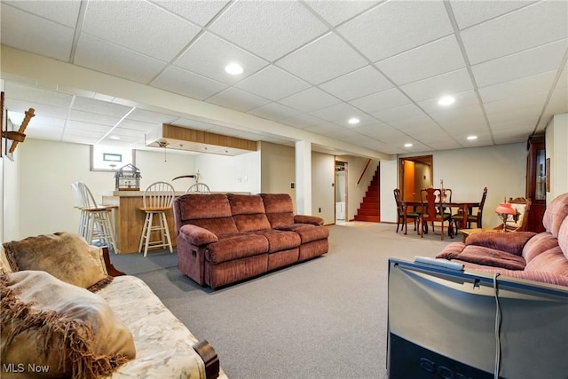 living room featuring bar area, recessed lighting, carpet, stairway, and a paneled ceiling