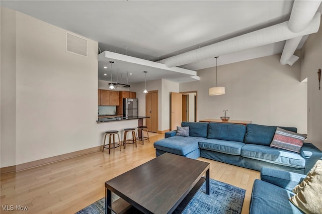 living room with visible vents, lofted ceiling with beams, baseboards, light wood-type flooring, and recessed lighting