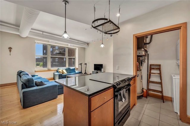 kitchen with light wood-style floors, black / electric stove, a peninsula, baseboards, and open floor plan