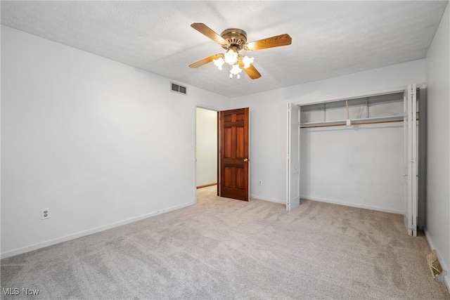 unfurnished bedroom featuring visible vents, a ceiling fan, carpet floors, and a closet