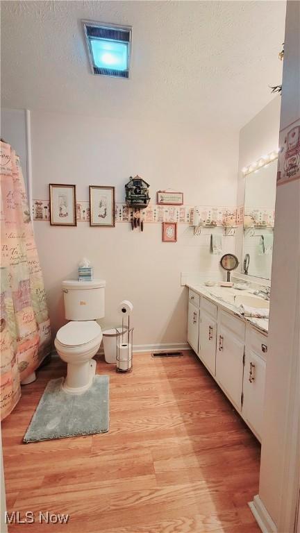 813 Brentwood Dr, Belpre, OH 45714 - full bath with vanity, a textured ceiling, wood finished floors, and toilet