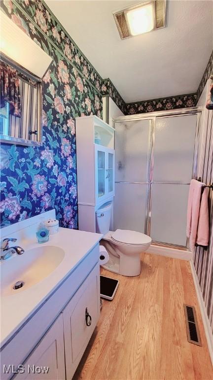 813 Brentwood Dr, Belpre, OH 45714 - bathroom featuring visible vents, a shower stall, wood finished floors, and wallpapered walls