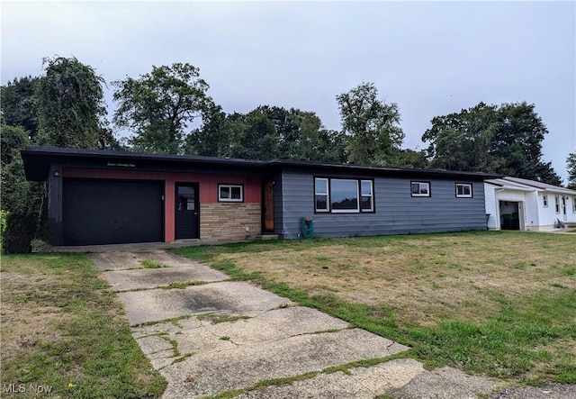 ranch-style house with concrete driveway, a front yard, and an attached garage