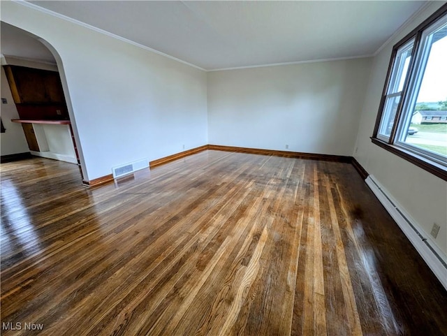 spare room with a baseboard heating unit, arched walkways, hardwood / wood-style flooring, and baseboards