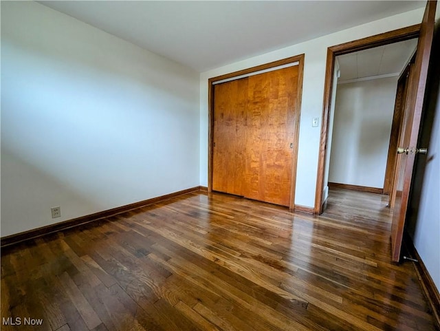 unfurnished bedroom with dark wood-style floors and baseboards