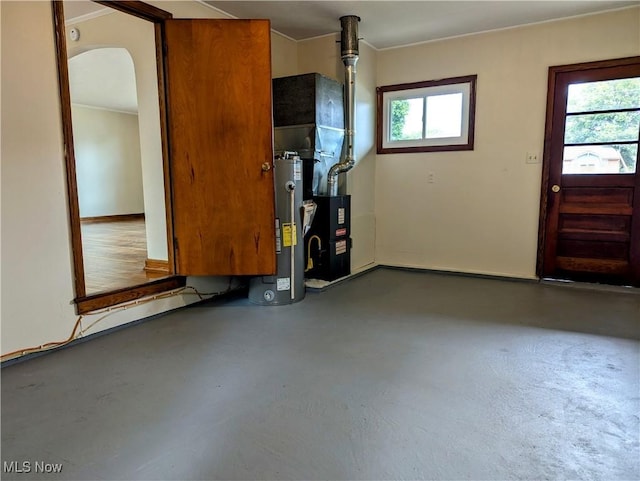 entryway featuring water heater, concrete flooring, and arched walkways