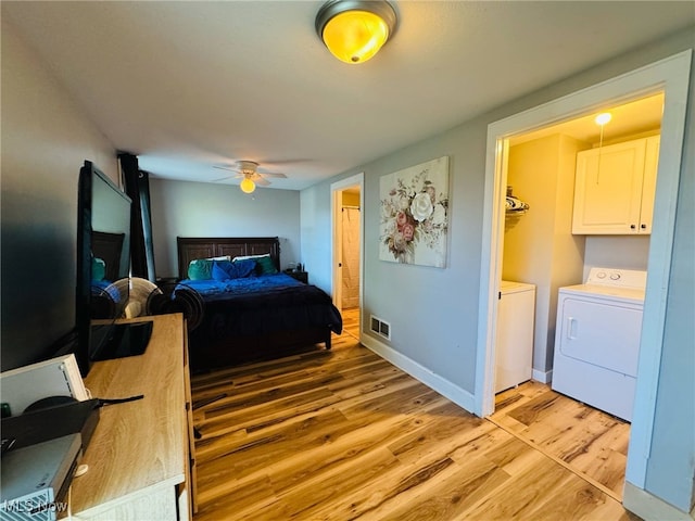 bedroom with light wood-style floors, ceiling fan, visible vents, baseboards, and washer and dryer