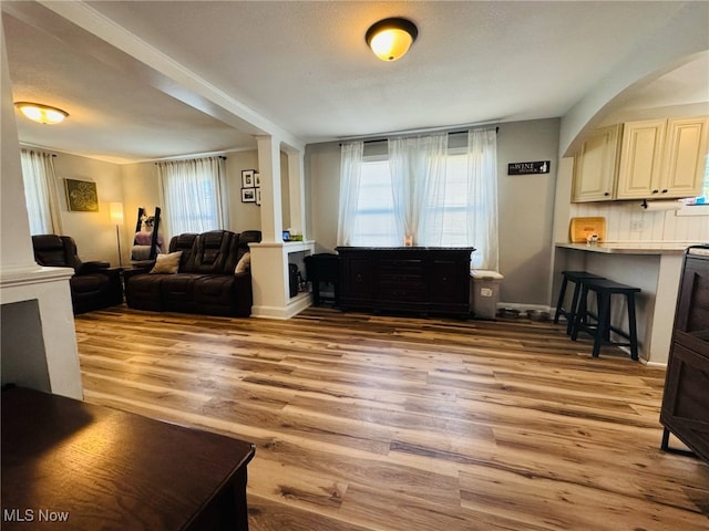 living area featuring baseboards and light wood finished floors