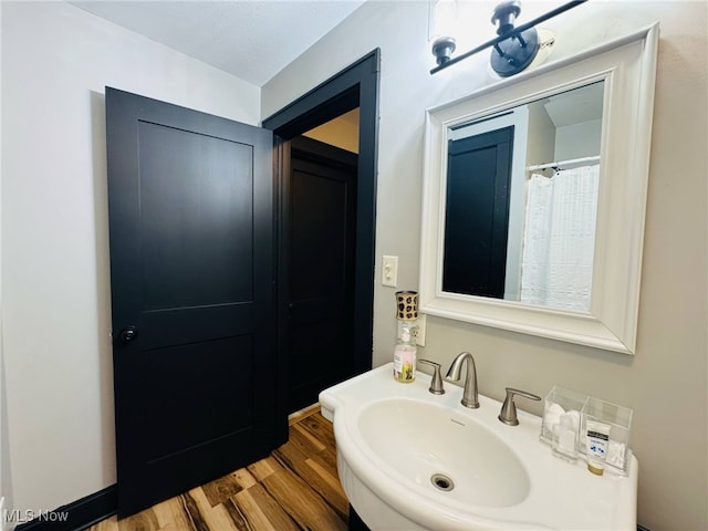 full bath featuring a sink and wood finished floors