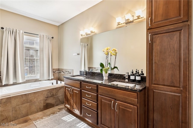 full bath featuring double vanity, tile patterned flooring, a bath, and a sink