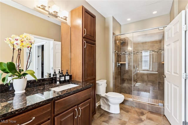 bathroom featuring a stall shower, toilet, and vanity