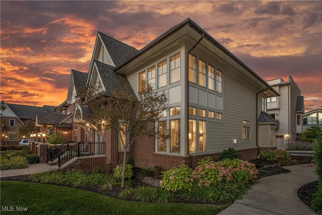 property exterior at dusk with brick siding