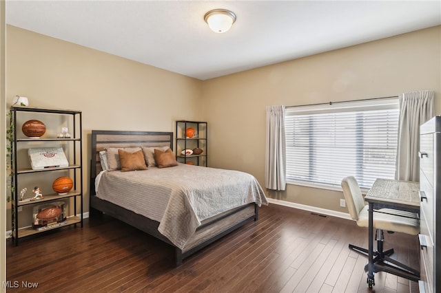 bedroom featuring visible vents, hardwood / wood-style floors, and baseboards