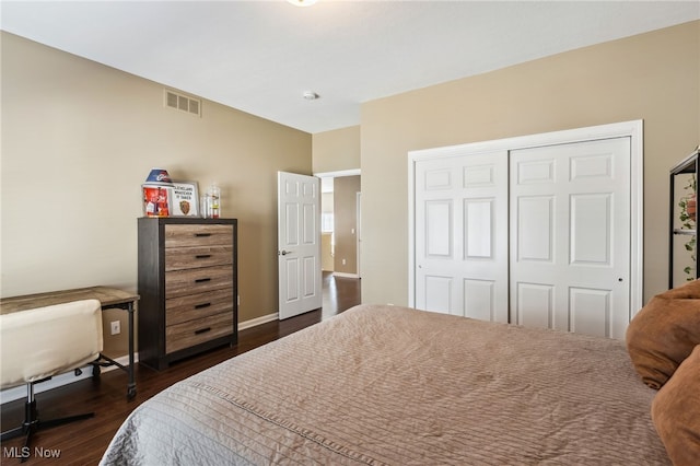 bedroom with a closet, visible vents, baseboards, and dark wood-type flooring