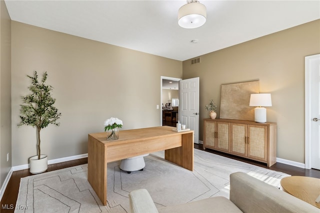 office space featuring visible vents, light wood-type flooring, and baseboards