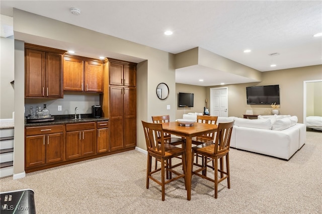 dining space featuring recessed lighting, baseboards, wet bar, and light carpet
