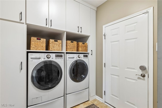 washroom featuring baseboards, cabinet space, and independent washer and dryer