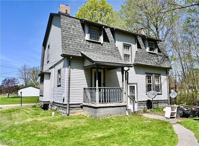 colonial inspired home with a chimney, a front yard, and a shingled roof