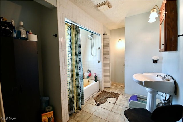 full bathroom featuring visible vents, shower / tub combo with curtain, a textured ceiling, and tile patterned flooring