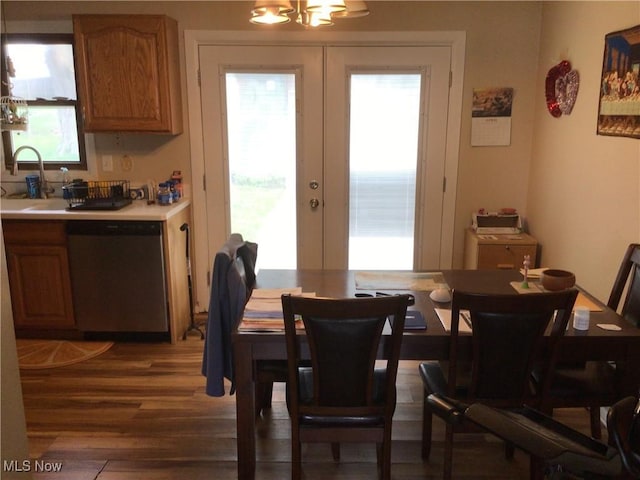 dining space with french doors, a chandelier, wood finished floors, and a healthy amount of sunlight