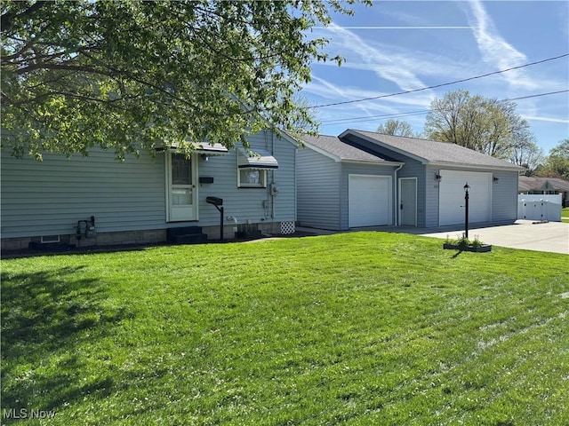 exterior space with a lawn, a detached garage, and entry steps