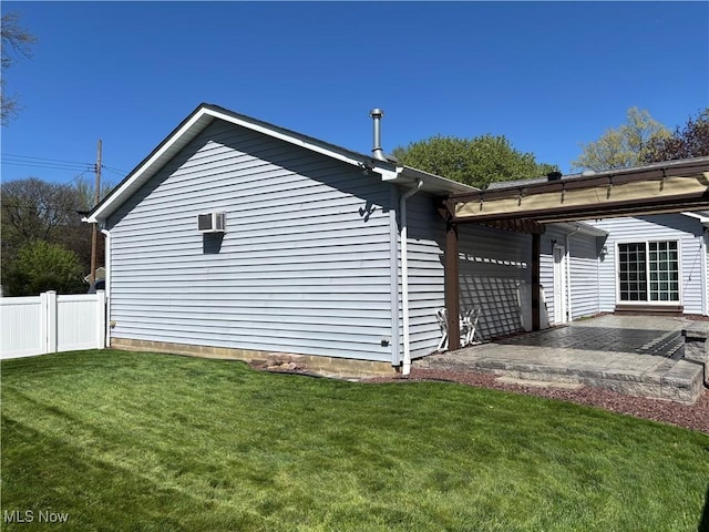 view of side of property featuring a patio, fence, and a yard