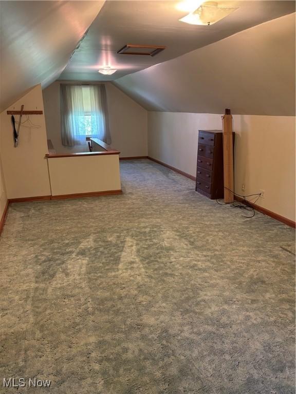 additional living space with lofted ceiling, carpet flooring, and baseboards