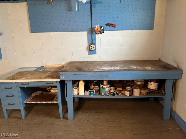 interior space with concrete block wall and a workshop area