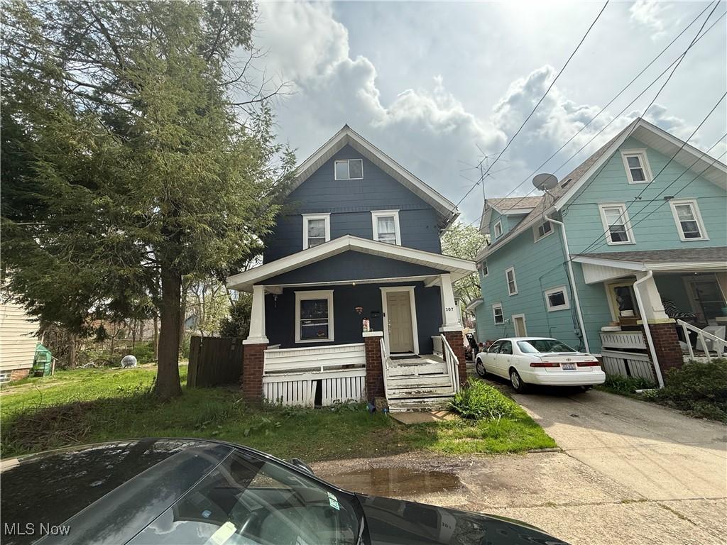 american foursquare style home featuring covered porch and driveway