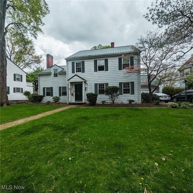 557 Cambridge Rd, Coshocton, OH 43812 - colonial home with a chimney, a standing seam roof, a front yard, and metal roof
