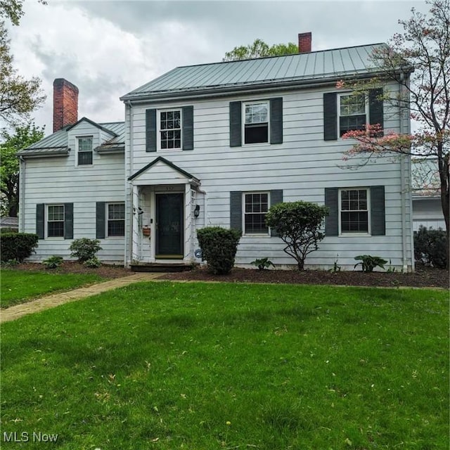 557 Cambridge Rd, Coshocton, OH 43812 - colonial-style house with metal roof, a front yard, a standing seam roof, and a chimney
